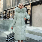 Woman wearing a mint green long quilted puffer coat with plush hood