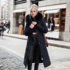 Woman wearing a black long quilted puffer coat with plush trim hood