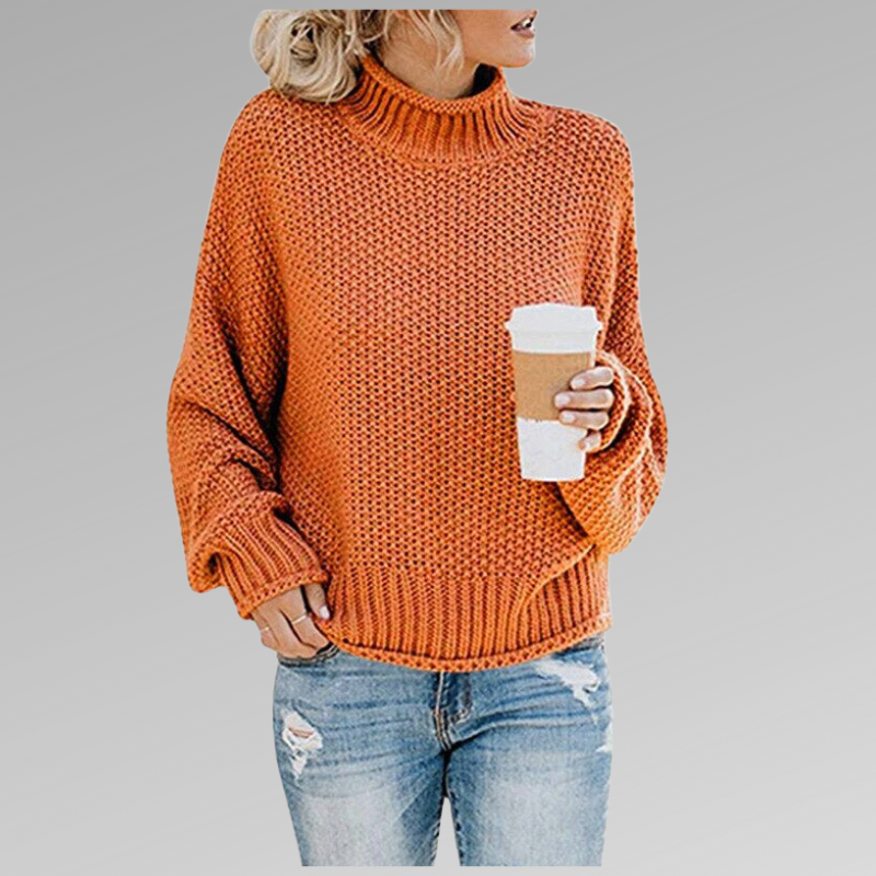 Woman wearing an orange loose knit sweater with jeans